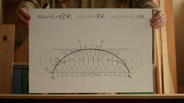 Mathematician shows paper with arc of cycloid curve. Reverse playback video. Date of shooting day 28 December, 2021 year, MSK time. This video was filmed in Russia.