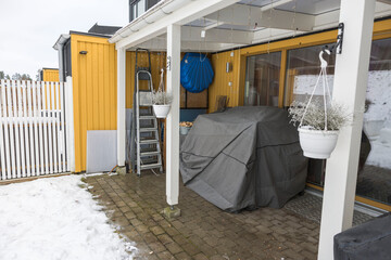 Obraz na płótnie Canvas Summer furniture under cover, on backyard of private house on winter day. Sweden.