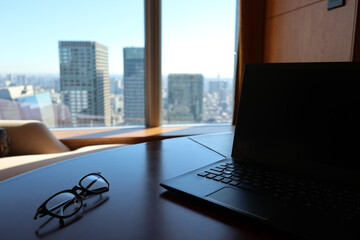 リモートワーク イメージ　高層ビルをのぞむ部屋で　remote working at the high floor room
