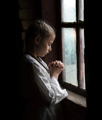 Girl at the window on a black background
