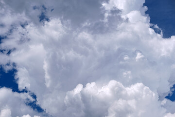 Bright landscape of white puffy cumulus clouds on blue clear sky