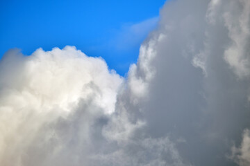 Bright landscape of white puffy cumulus clouds on blue clear sky