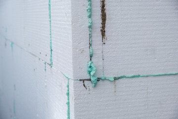 Installation of styrofoam insulation sheets on house facade wall for thermal protection