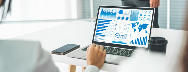 Businesswoman in business meeting using laptop computer proficiently at office for marketing data analysis . Corporate business team collaboration concept .