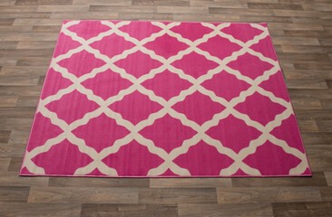 A pink and white patterned rug laid on the floor.