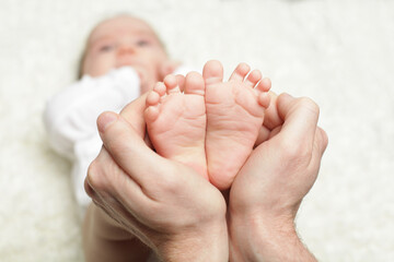 Parent holding in the hands feet of newborn baby