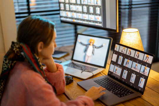 Young creative woman work on laptop and desktop computers editing photos at cozy home office. Portrait of female photographer at home workplace