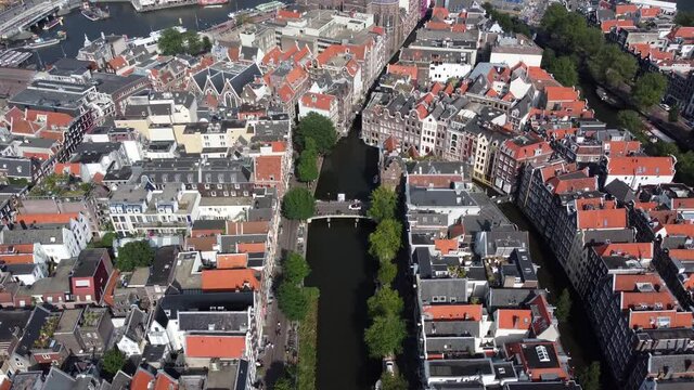 Aerial drone view of Amsterdam Red Light District moving over on of the canals towards ij lake in city center famous tourist attraction and destination in the Netherlands Europe 4k quality