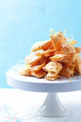 Italian carnival fritters dusted with powdered sugar. Selective focus. With free text space.