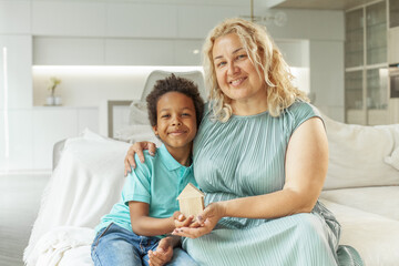 Happy family holding wooden house at home