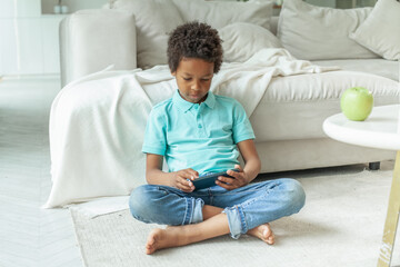 Serious child boy with phone playing game