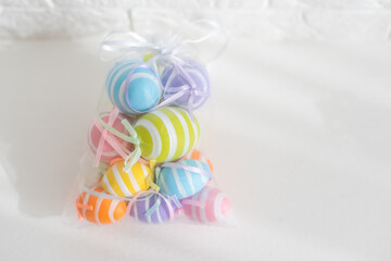 multi-colored chicken eggs in bag mesh on white background. easter