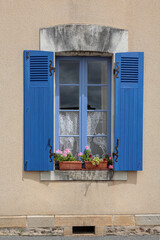 Fototapeta na wymiar fenêtre au volets bleus et pots de géraniums