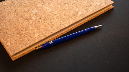 Korkowy zeszyt i niebieski długopis