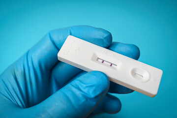 Closeup shot of a hand holding a positive antigen test