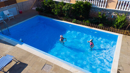 mother and daughter playing in a swimming pool