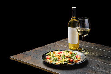 Salad with chicken and fresh vegetables with white wine on a table