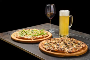 Fotobehang Two pizzas and a glass of beer and red wine on a table © boomeart