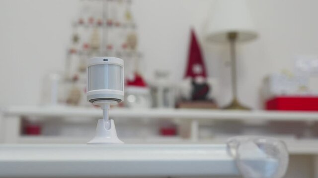 Wireless motion sensor installation in the room, small plastic white motion detector for smart home used to detect activities like movement and control smart lights. High quality 4k footage