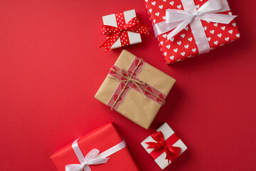 Top view photo of st valentine's day decorations presents craft paper gift box with ribbon and twine bow on isolated red background with copyspace