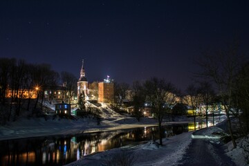 Fototapeta na wymiar Old town and river on a winter night. Valmiera, Latvia.