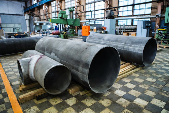 Large-diameter galvanized metal pipes are in a workshop at an industrial plant. Foreground. Selective focus