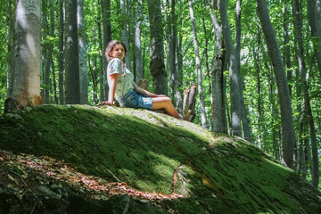 girl sitting on a mossy stone