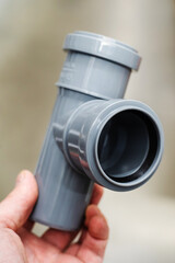 Double polypropylene pipe for sewerage system installation. Selection of piping parts in a specialist store. Close-up. Unrecognizable person