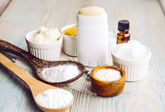 Making homemade deodorant stick with all natural ingredients concept. Wooden background. Ingredients: arrowroot powder, baking soda, beeswax, shea butter, essential oil, cornstarch, coconut oil.