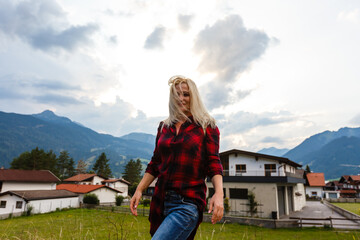 Naklejka premium woman enjoying beauty of nature looking at mountain. Adventure travel, Europe. Woman stands on background with Alps.