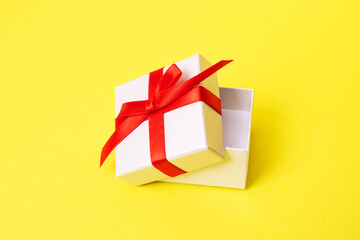 White box with a gift on a yellow background