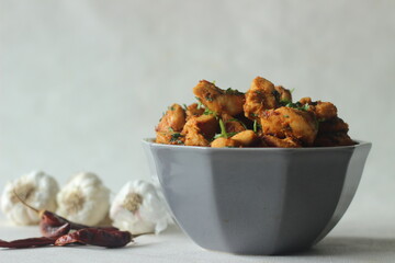 Chilli garlic chicken bites. A pan fried chicken dish with a strong garlic flavour and garnished with fresh coriander leaves.