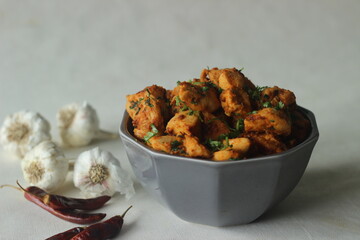 Chilli garlic chicken bites. A pan fried chicken dish with a strong garlic flavour and garnished with fresh coriander leaves.