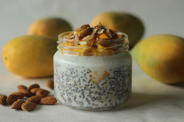 Overnight oats with mango and almonds. Made by soaking rolled oats and chia seeds in milk served with chopped mangoes, almonds and honey