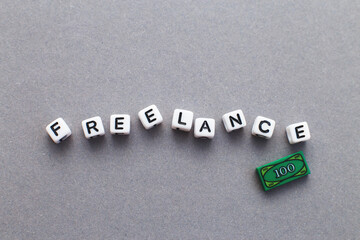 word freelance made from plastic cubes of beads on gray background
