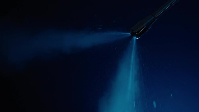 Slow motion purging steam wand of coffee machine under neon lighting