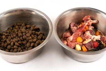 Two bowls with dog food, processed and natural stuff. Comparing of different kind of diet. The process of changing from one system to another. White background, copy space.