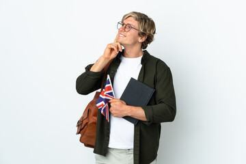 Naklejka premium Young English woman holding an United Kingdom flag thinking an idea while looking up