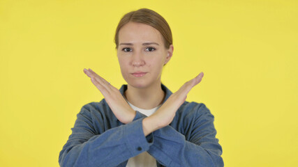 Young Woman Showing No Sign by Arm Gesture on Yellow Background