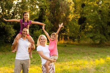 Fototapeta premium Happy family enjoying life together at meadow outdoor.