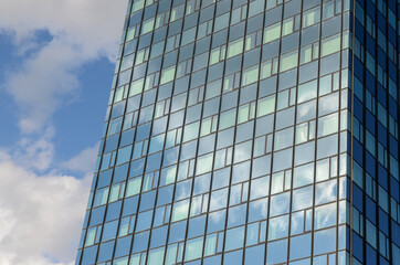 Fototapeta na wymiar Tall skyscraper in town. Glass facade on a modern building.