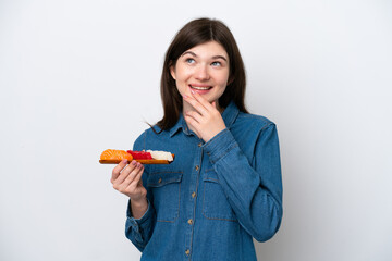 Young Russian woman holding sashimi isolated on white background looking up while smiling