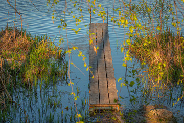 Wooden pier in the lake at sunset in summer