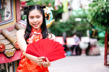 Asian woman wearing cheongsam and holding red envelope in new year chinese festival.