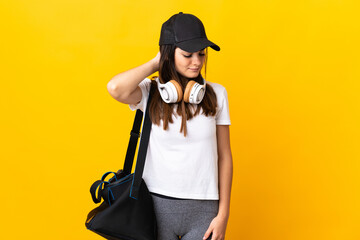 Young sport woman with sport bag isolated on yellow background with neckache