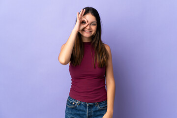 Young caucasian woman isolated on purple background showing ok sign with fingers