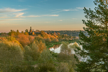 October countryside landscape with river and church