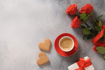 Coffee and two heart shaped cookies for Valentine's day. Bouquet of red roses and love gift.