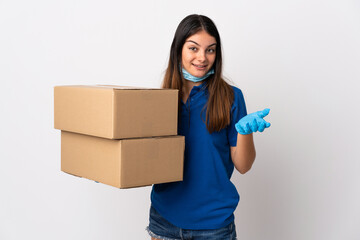 Young delivery woman protecting from the coronavirus with a mask isolated on white background with shocked facial expression