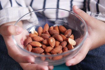 child holding a bowl of almond 